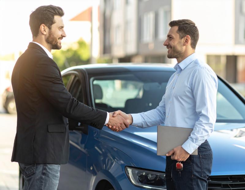 Sprzedaż auta używanego – kupujący i sprzedający przy samochodzie